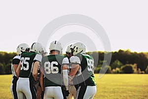 American football team in a huddle on a sports field