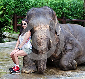 American girl with asian elephant at a conservation park in Bali, Indonesia. Beautiful woman tourist.