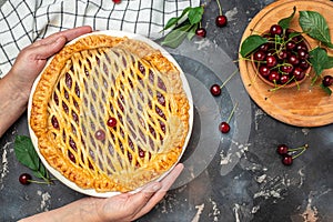 American homemade cherry pie, Female hands holding whole homemade cherry pie, banner, menu, recipe place for text, top view