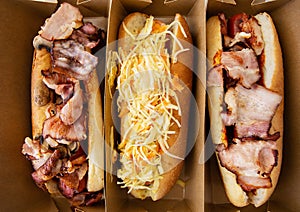 American hot dog with different flavors, with cheese and crispy onions on a white table in a minimalist style. Fast food, takeaway
