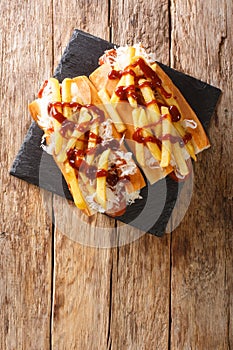 American hot dog polish boy with sausage, cabbage and fries close-up. vertical top view