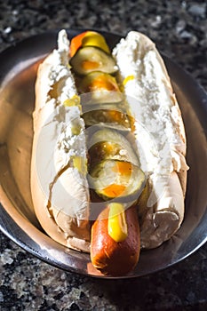 american hot dog with sausage, mustard, pickle and barbecue sauce, selective focus and copy space