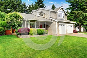 American house exterior with double garage and well kept lawn.