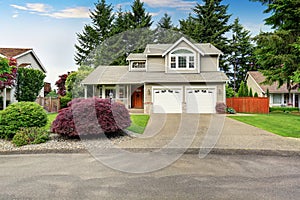 American house exterior with double garage and well kept lawn.