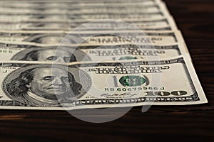 american hundred-dollar bills operating in the United States located on an adorned wooden background