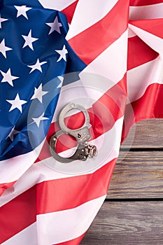 American justice handcuffs on flag, top view.