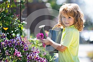 American kids childhood. Child watering flowers in garden. Home gardening