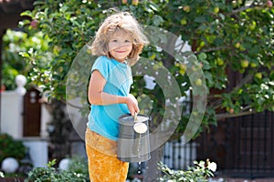 American kids childhood. Child watering flowers in garden. Home gardening