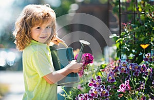 American kids childhood. Child watering flowers in garden. Home gardening