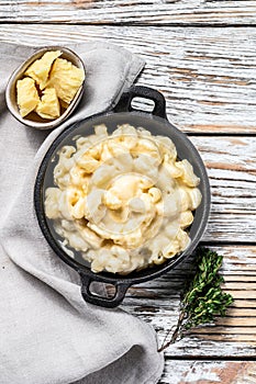 American mac and cheese, macaroni pasta in cheesy sauce. White wooden background. Top view photo