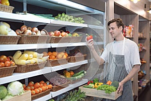 American man grocery working in supermarket with fruit and vegetable background