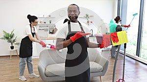 American man professional cleaning worker pointing on bucket with detergents.