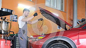 American mechanic working in a car service center. Repair and maintenance of electric vehicles