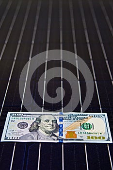 American money on solar panel surface. Renewable energy cost