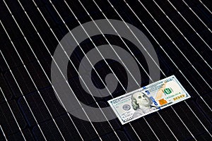 American money on solar panel surface. Renewable energy cost photo