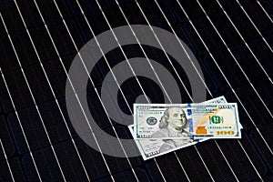 American money on solar panel surface. Renewable energy cost photo