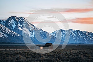 An American Mormon pioneer barn on Mormon Row in Grand Teton National Park during sunrise. Wyoming, USA.