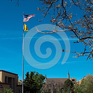 American and New Mexico flags fly over historic Loretto Chapel in Santa Fe, New Mexico, USA