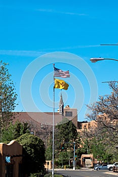 American and New Mexico flags fly over historic Loretto Chapel in Santa Fe, New Mexico, USA