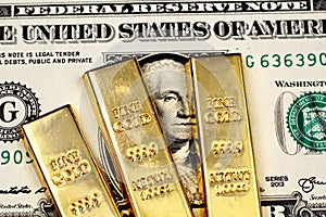 American one dollar bill with three small gold bars