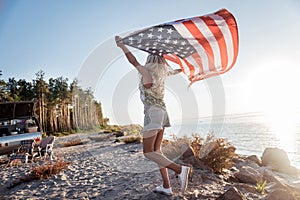 American patriotic woman traveling in compact trailer with her flag