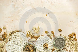 American puffed rice cakes. Healthy snacks with ears of wheat on light pink concrete surface, top view, flat lay, copy space for