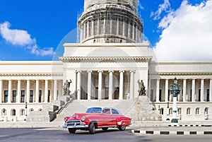 American red 1952 classic car on the street Paseo de Marti in before the Capitolio in Havana City Cuba - Serie Cuba
