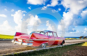 American red 1959 vintage car parked on the fortress el Morro near the beach in Havana Cuba - Serie Cuba Reportage