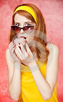 American redhead girl in sunglasses with cake.