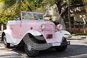 American rose Ford convertible classic car parked under palms in Varadero Cuba - Serie Cuba Reportage