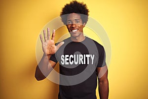 American safeguard man with afro hair wearing security uniform over isolated yellow background showing and pointing up with