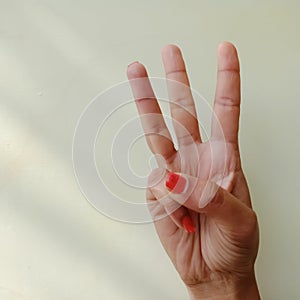 american sign language alphabet letter W displayed with isolated hand on light background