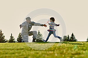 American soldier meet his daughter outdoor.
