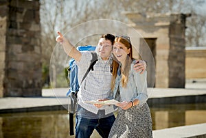 American student and tourist couple reading city map in tourism concept