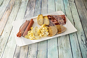 American-style breakfast with pancakes, scrambled eggs, muffins, pork sausage,
