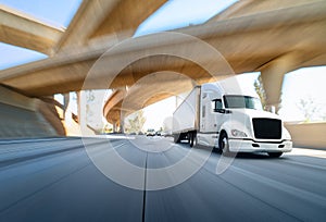 American style truck on freeway pulling load. Transportation theme. Road cars theme. Truckers heaven. Trailer passing the bridge