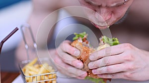 American style. Young man eating burger. People eat unhealthy meal. Getting satisfaction from unhealthy food.