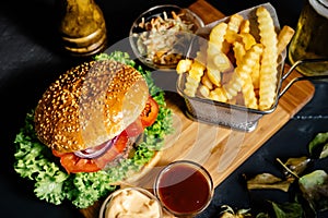 american stylish beef burger with grilled meat and mayo served with fries, coleslaw and beer