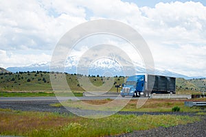 American stylish big rig blue semi truck with black rubberized f