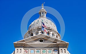 American and Texas state flags flying on the dome of the Texas State Capitol building in Austin