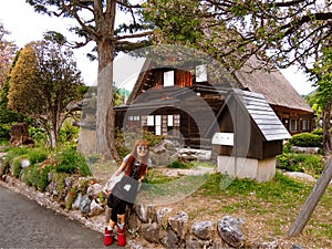 American tourist in front of a cozy house inside a traditional and historic japanese village of Shirakawa-gÅ and Gokayama