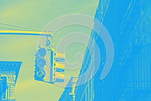 American traffic light and skyscrapers, fragment. Blue and yellow toned