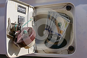 American or US Dollars fitted into a fuel filler or gas hole of a car\'s fuel tank.