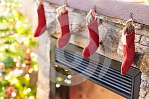 American, US dollars in Ñhristmas red socks for gifts on the fireplace in bokeh lights.