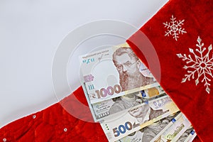 American, US dollars and Ukrainian hryvnia in christmas red socks for gifts