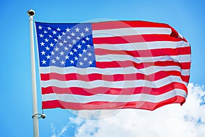 American US flag on a pole, against blue sky