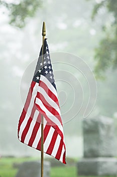 American veteran flag in foggy cemetery