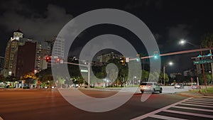 American wide multilane street intersection with traffic lights and moving cars at night. Transportation system in USA.