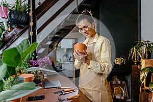 american woman florist got order at counter of her flower shop, occupation working concept. Smiling plant store female