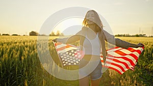 American woman proudly holding American flag at sunset field, celebrate 4th of July